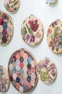Embroidered hoop art by textile artist Corinne Young, arranged on a wall. Photo by Colin Poole for HomeStyle Magazine (June 2016).