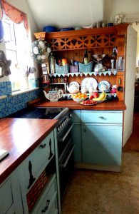 The kitchen in Corinne Young's home, with wooden worktops and kitchen units painted turquoise. Photo by Jonathan Gawthorpe for Yorkshire Post Magazine (June 2014).