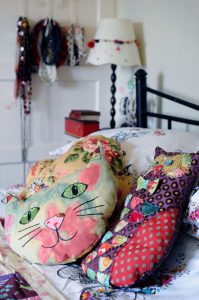 The second bedroom in Corinne Young's home, with cushions hand-made by Corinne. Embroidered pot plants by textile artist Corinne Young. Photo by Jonathan Gawthorpe for Yorkshire Post Magazine (June 2014).