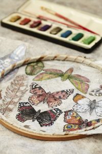 Hand-painted butterflies by Corinne Young in a hoop and ready for embroidering. Photo by Alun Callender for Country Living Magazine (September 2017).