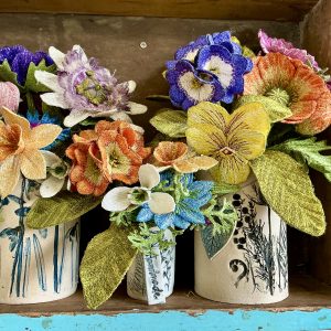 Embroidered flower stems by Corinne Young, displayed in hand-made vases by the Ceramic Botanist.